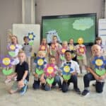 Blumen mit Schulkindern der GS Mühlenbergschule Osloß, Begrüßung im Klassenzimmer, Lernumfeld und Schüleraktivitäten.