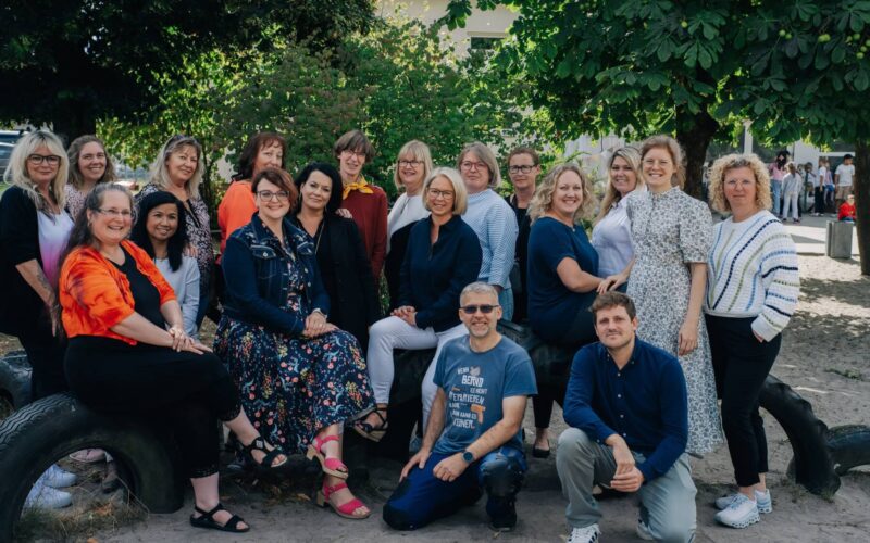 DSC_2678 Gruppenfoto der Lehrkräfte an der GS Mühlenbergschule Osloß, umgeben von grünen Bäumen, bei einem Schulfest oder Treffen.